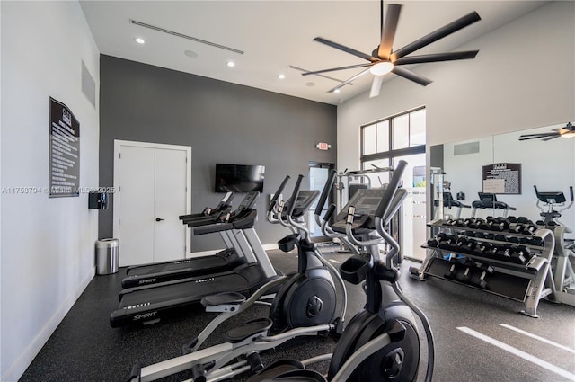 workout area with a high ceiling, a ceiling fan, visible vents, and baseboards