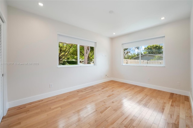 spare room with recessed lighting, baseboards, and hardwood / wood-style floors