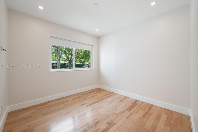 spare room featuring recessed lighting, baseboards, and wood finished floors