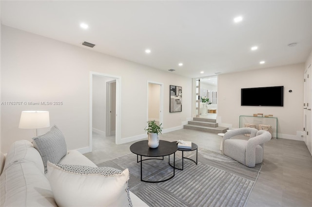 living area with recessed lighting, visible vents, and baseboards