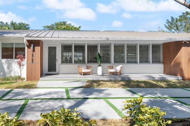 back of house with a standing seam roof and metal roof