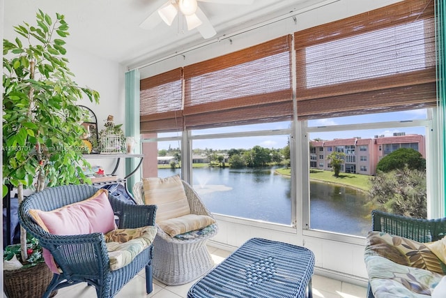 sunroom / solarium with a ceiling fan and a water view