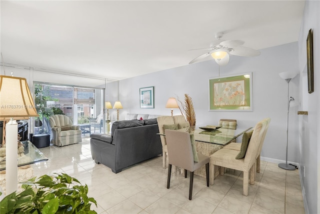 dining room featuring a wall of windows, light tile patterned floors, and a ceiling fan