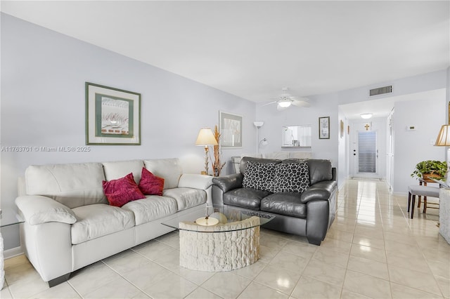 living room featuring light tile patterned flooring, baseboards, visible vents, and ceiling fan