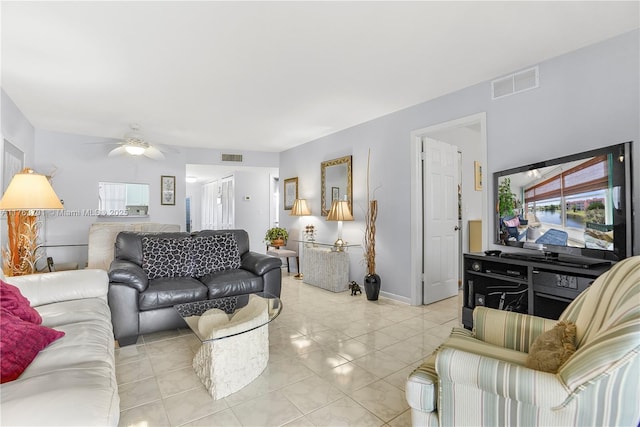 living area with light tile patterned floors, visible vents, and ceiling fan