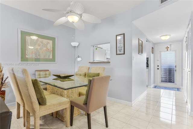 dining room with visible vents, light tile patterned flooring, a ceiling fan, and baseboards