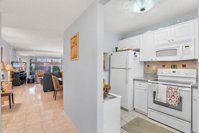 kitchen with open floor plan, light tile patterned floors, decorative backsplash, white appliances, and white cabinetry