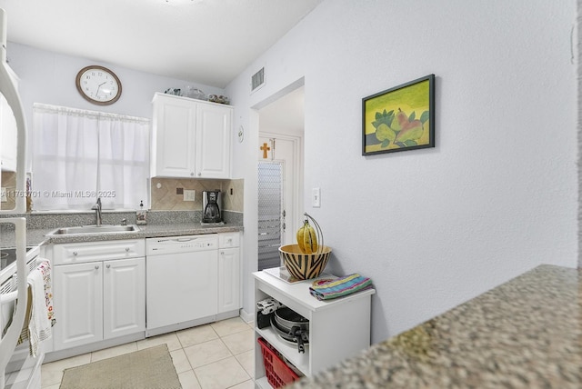 kitchen featuring tasteful backsplash, visible vents, white appliances, white cabinetry, and a sink