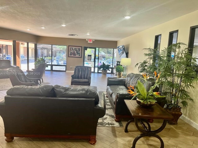 living area featuring a textured ceiling and baseboards