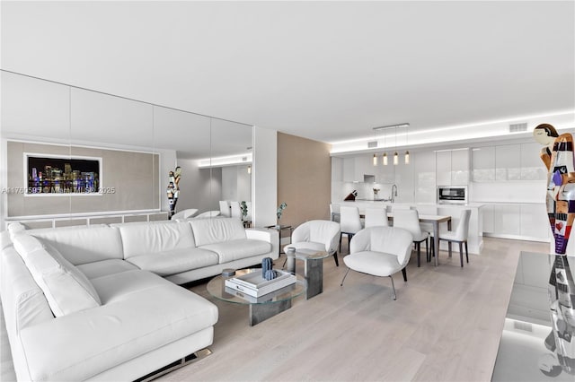 living room with visible vents and light wood-type flooring