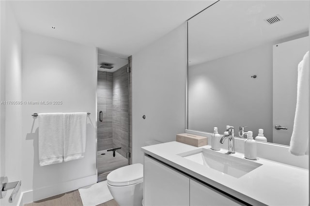 bathroom featuring visible vents, toilet, a stall shower, and vanity