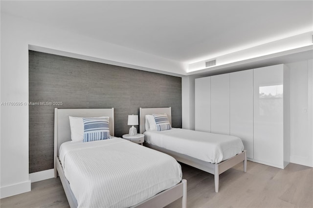 bedroom featuring visible vents, baseboards, and light wood-style flooring