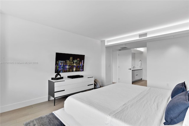 bedroom with light wood-style flooring, baseboards, and visible vents