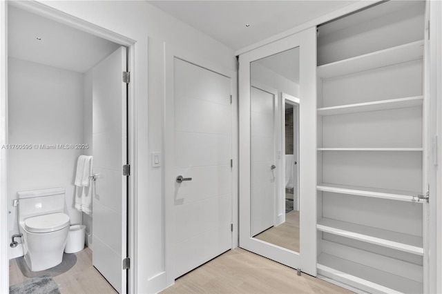 bathroom with toilet and wood finished floors