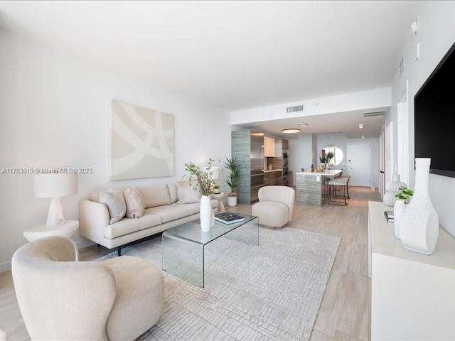 living room featuring visible vents and light wood finished floors