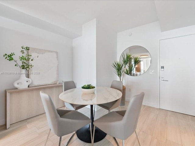 dining area featuring light wood finished floors and radiator heating unit