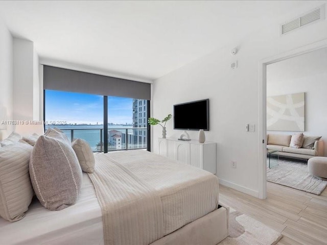 bedroom with visible vents, light wood-type flooring, and baseboards