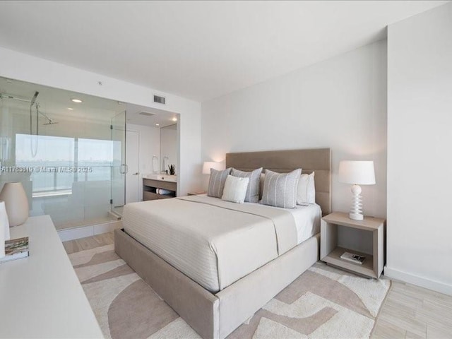 bedroom featuring visible vents, light wood-style flooring, and baseboards