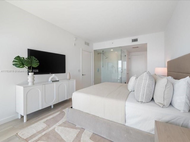 bedroom with wood finished floors, visible vents, and baseboards