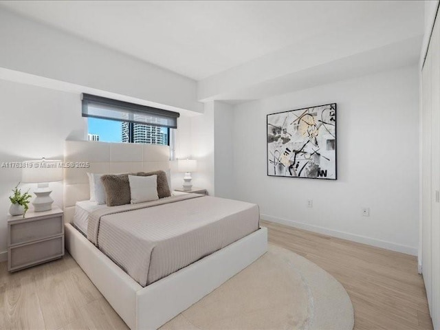 bedroom with light wood-style floors and baseboards