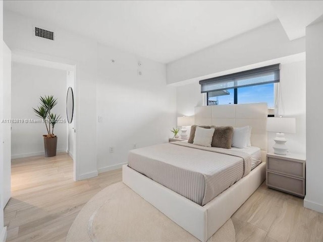 bedroom with visible vents, baseboards, and light wood-style floors