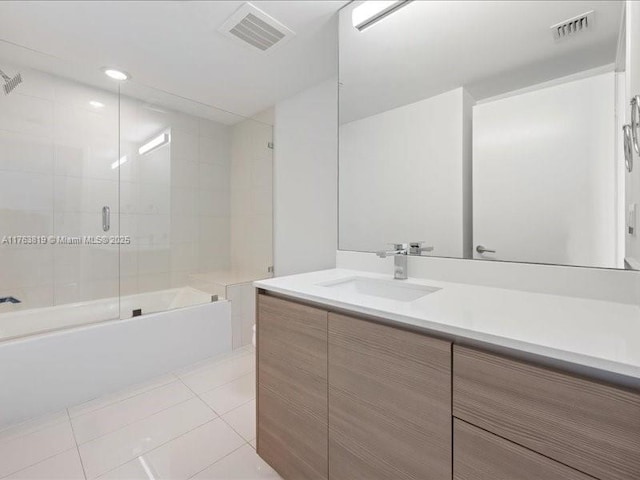 bathroom featuring tile patterned flooring, visible vents, combined bath / shower with glass door, and vanity