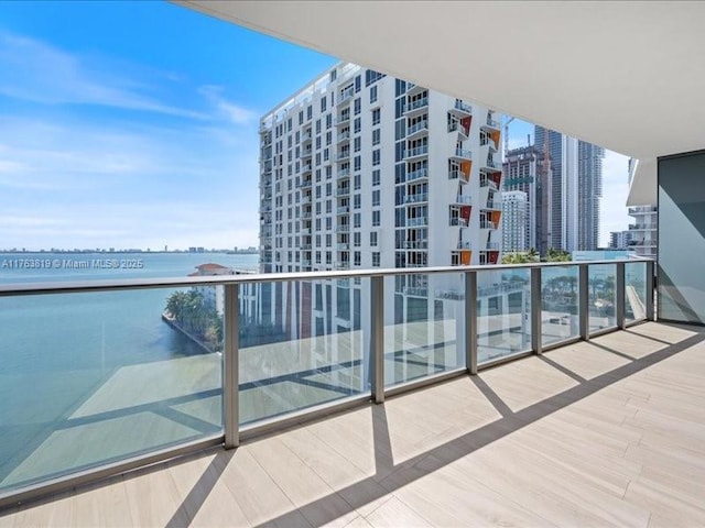 balcony with a water view and a view of city