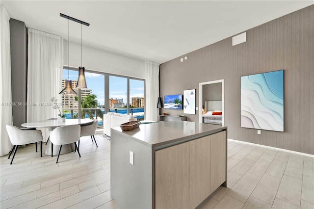 kitchen with a kitchen island, wood tiled floor, hanging light fixtures, light countertops, and modern cabinets