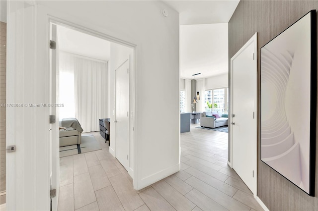 hall featuring baseboards and wood finish floors