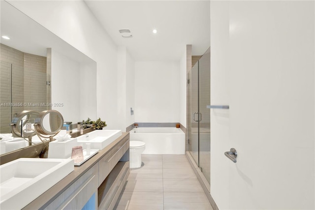 bathroom with double vanity, a sink, a shower stall, a garden tub, and tile patterned floors