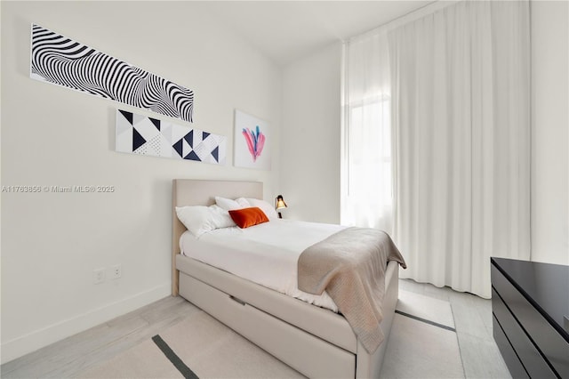 bedroom featuring baseboards and light wood-style floors