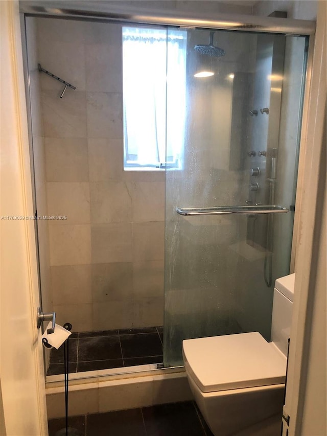 bathroom with a shower stall and toilet