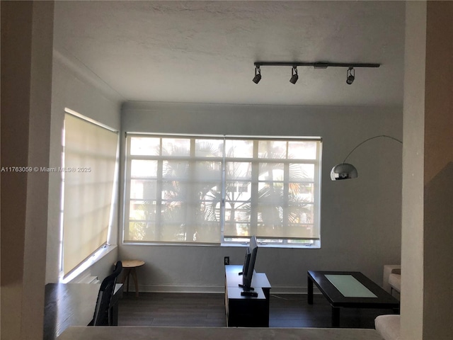 home office featuring track lighting, baseboards, and wood finished floors