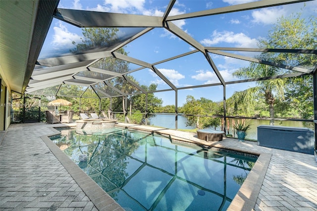 view of pool featuring a water view, a pool with connected hot tub, a lanai, and a patio area