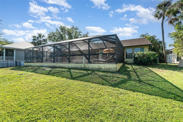 back of property with glass enclosure and a yard