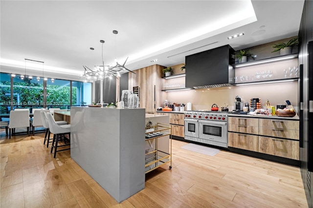 kitchen with double oven range, a breakfast bar area, exhaust hood, modern cabinets, and open shelves