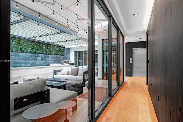 interior space with elevator, hardwood / wood-style floors, and rail lighting