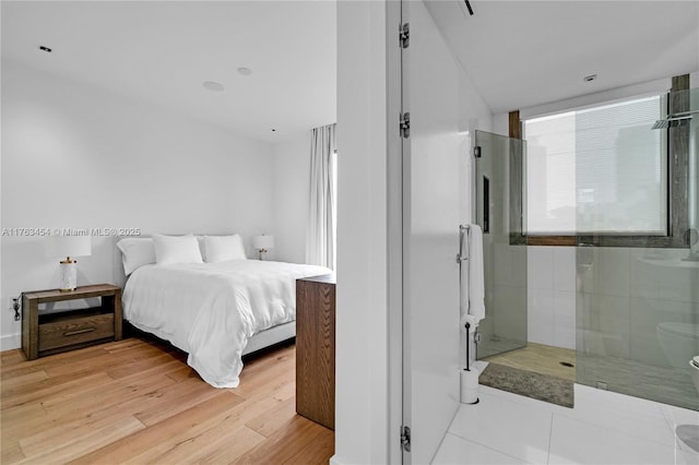 bedroom with multiple windows and light wood finished floors