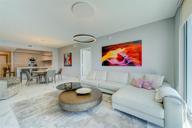 living area with visible vents and marble finish floor