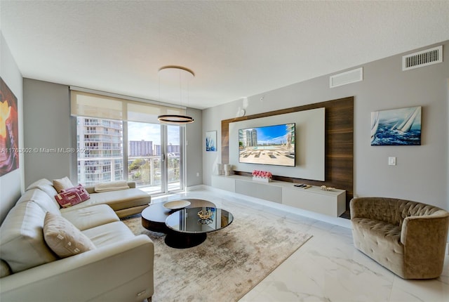 living room featuring visible vents, a textured ceiling, and marble finish floor