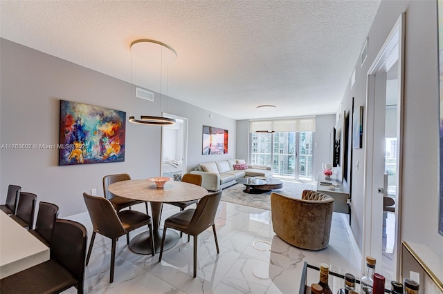 dining area featuring visible vents, marble finish floor, and a textured ceiling