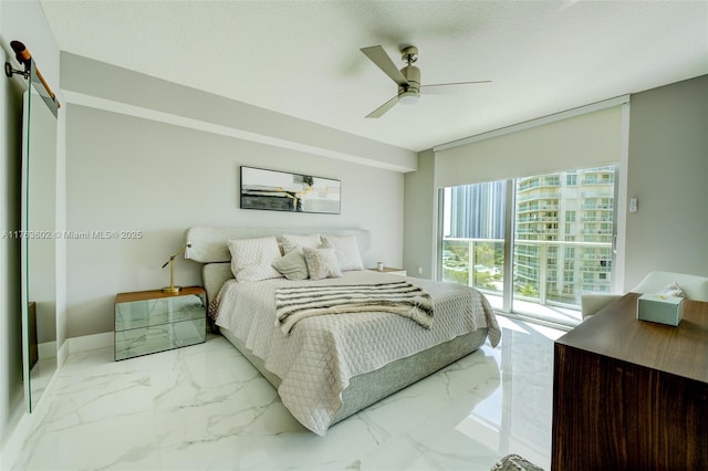 bedroom with baseboards, ceiling fan, a barn door, marble finish floor, and a textured ceiling