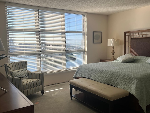 bedroom featuring multiple windows, carpet, and a textured ceiling