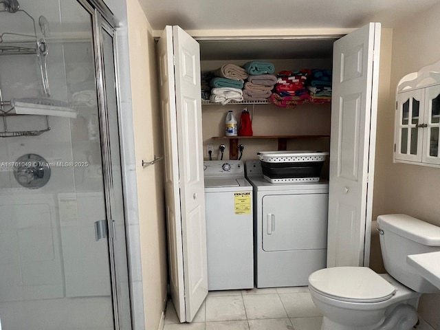 bathroom featuring a shower stall, toilet, and independent washer and dryer