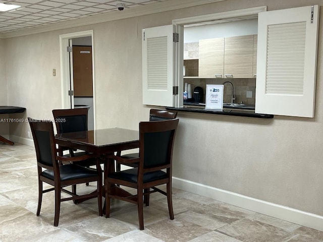 dining space with crown molding and baseboards