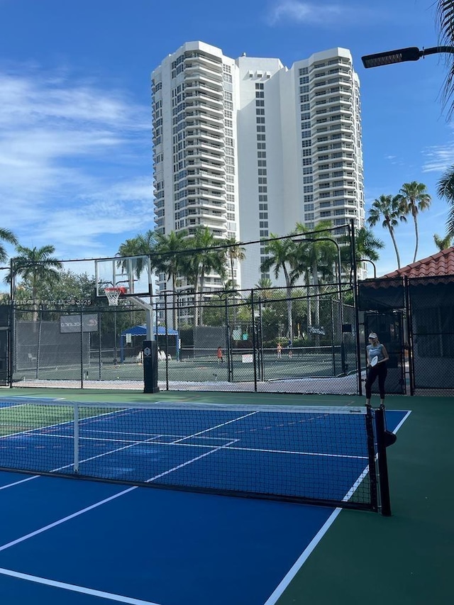 view of tennis court with a gate, community basketball court, and fence