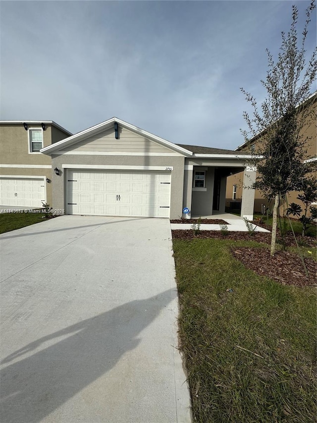 view of front of house featuring a garage, driveway, and stucco siding