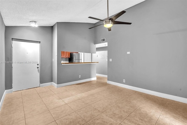 unfurnished living room with visible vents, baseboards, light tile patterned floors, a textured ceiling, and a ceiling fan