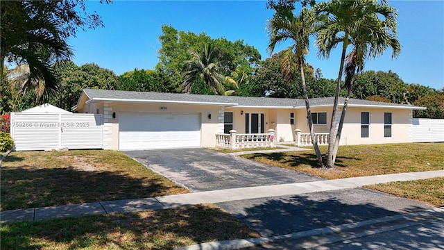 single story home featuring fence, driveway, an attached garage, stucco siding, and a front lawn