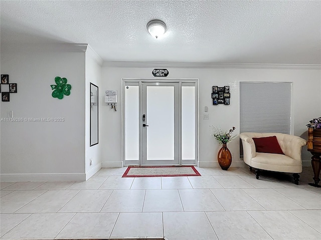 entryway with light tile patterned floors, baseboards, and a textured ceiling